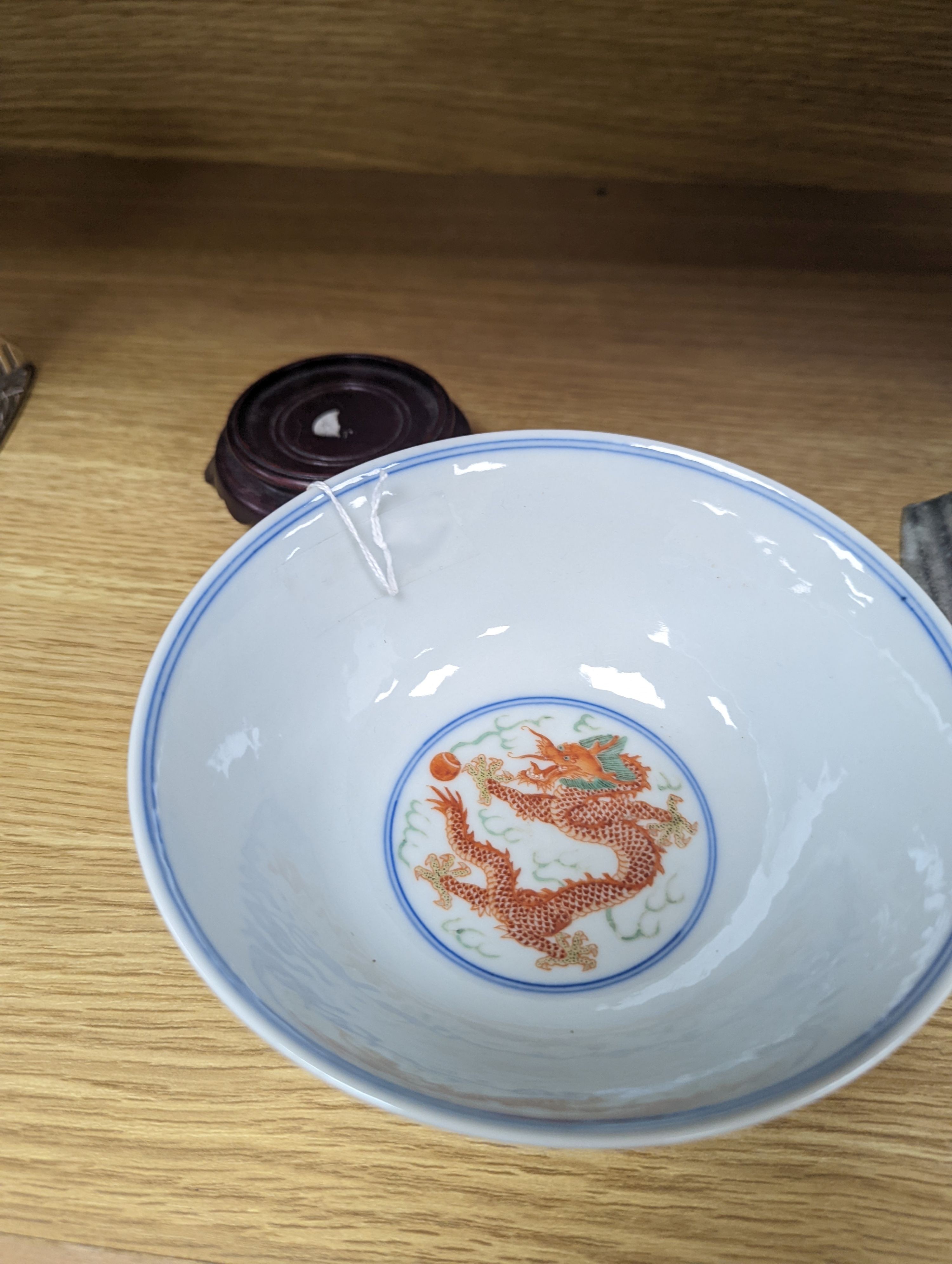 A Wucai bowl, dragon and flamingo pearl decoration, Jiaqing mark, on wood stand. 16cm diameter